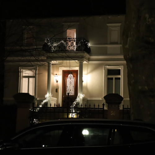 Lichtergirlanden am Eingang und am Balkon einer Villa.